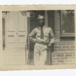 Soldier leaning against a brick building