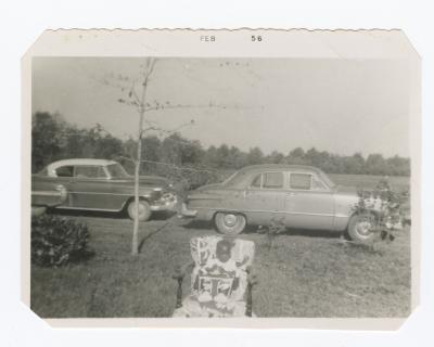 Baby seated in front of cars