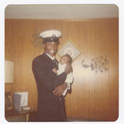 Man in naval uniform holding a baby