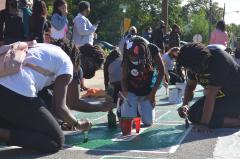 Young ladies painting Black Lives Matter street mural
