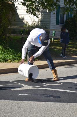 Man pouring paint for Black Lives Matter mural
