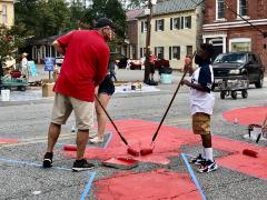 Mayor Chris Cerino painting the Black Lives Matter street mural with a young boy