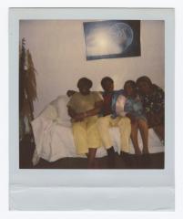 Four people sitting on a cloth covered couch