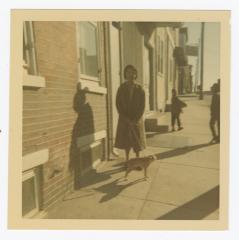 A woman walking a small dog