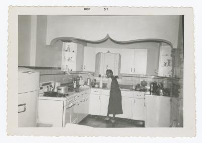 A woman washing dishes and looking over her shoulder