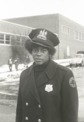 Unidentified African American female police officer acting as a crossing guard for Garnet High School
