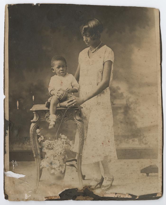 A woman posed with a child on an ornate table