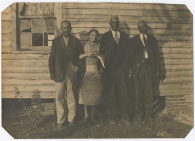 Four people standing on the side of a house