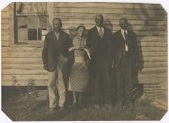 Four people standing on the side of a house