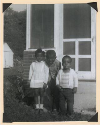 Three children outside house