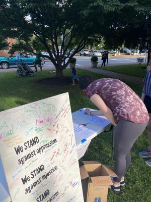 Signing the Community Commitment Mural at We Stand: Day of Agreement